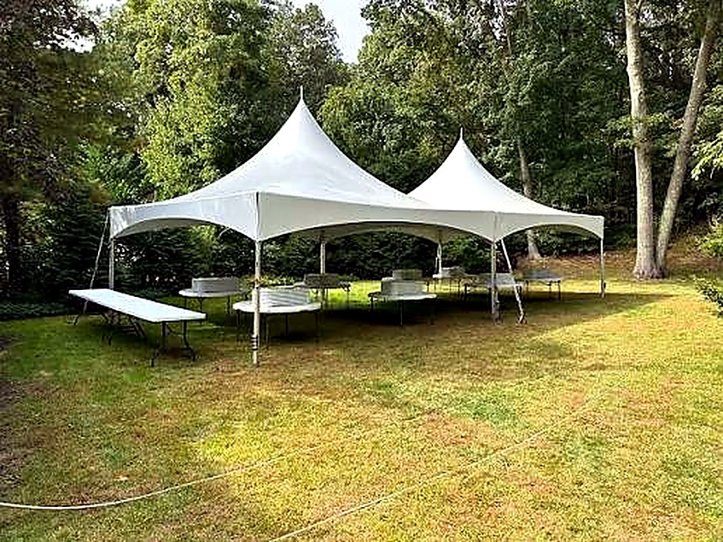 Connected white High Peak event tents in a green outdoor setting