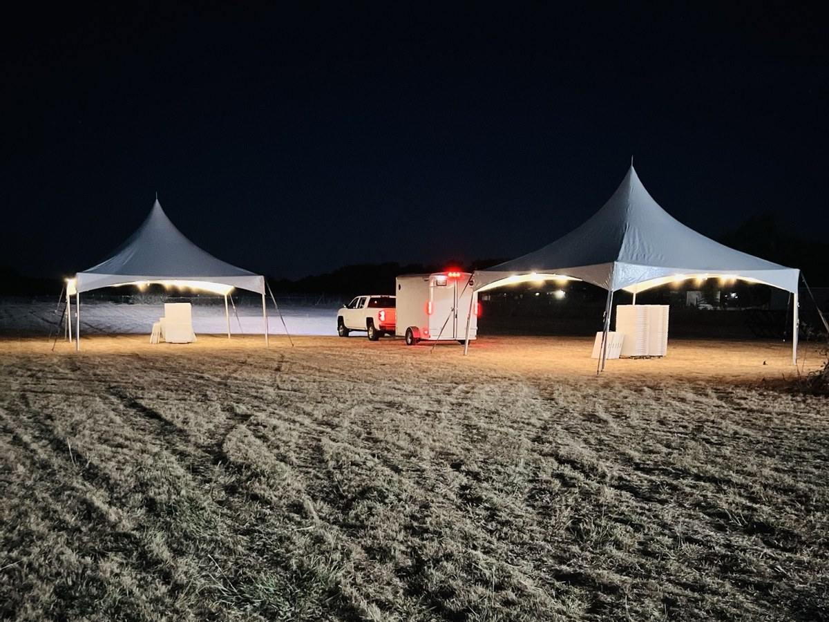 Two illuminated High Peak tents prepared for an event
