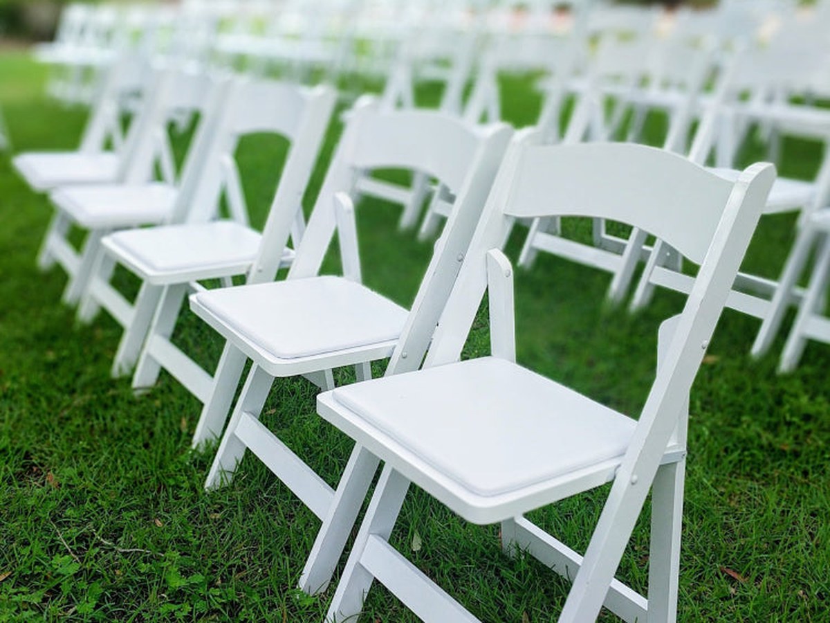 White resin folding chairs arranged for an event