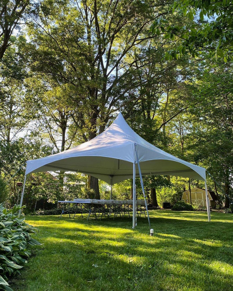 White High Peak tent with tables on a green lawn